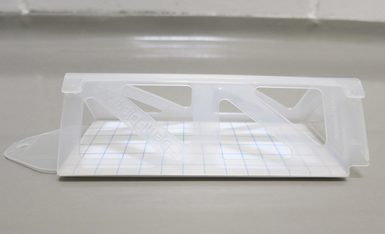 A pheromone trap sitting on a grey floor.